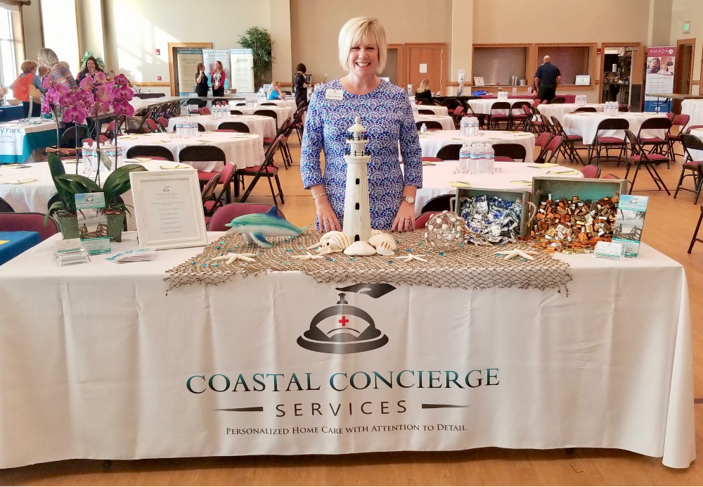 Eileen standing behind a display table with a lighthouse centerpiece